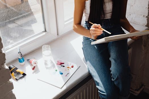 a person painting in a sunlit studio, surrounded by art supplies